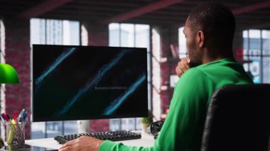 Siyah serbest çalışan, iş konferansını PC monitöründen izliyor, istatistik tablolarına bakıyor. Apartman ofisindeki uzaktan çalışan bilgisayardaki sunum grafiklerini takip ediyor. Kamera A.