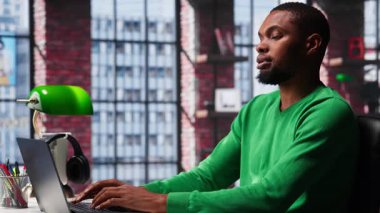 Bilgisayarda hesap tablolarını tamamlayan Afrikalı Amerikalı erkek tele-işçi hücrelere sayısal verileri giriyor ve toplamları hesaplıyor. Yazılım işlevlerini kullanan bir adam. Kamera A.