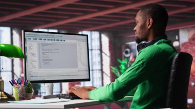 Teknolojiden anlayan siyah mühendis evde güvenli çevrimiçi program geliştiriyor. İkili verilerle çevrili olan serbest çalışan arayüz tasarımı, senaryo optimizasyonları ve ağ sistemleri üzerinde çalışıyor. Kamera A.