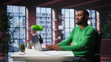 Bilgisayarda hesap tablolarını tamamlayan Afrikalı Amerikalı erkek tele-işçi hücrelere sayısal verileri giriyor ve toplamları hesaplıyor. Yazılım işlevlerini kullanan bir adam. Kamera B.