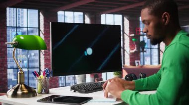 Siyah serbest çalışan, iş konferansını PC monitöründen izliyor, istatistik tablolarına bakıyor. Apartman ofisindeki uzaktan çalışan bilgisayardaki sunum grafiklerini takip ediyor. Kamera B.