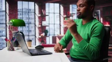 Siyahi serbest çalışan, kâr ve ulaşımı arttırmak için yeni çözümler düşünüyor, finansal büyüme için fikir üretmek için birden fazla iş yapıyor. Genç uzaktan kumandalı işçi, yaratıcılığını başarı için kullanır. Kamera B.