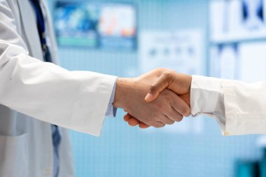 Sağlık personeli kabine toplantısının sonunda doğru teşhis ve tedavi planını bulmak için tokalaşıyor. Doktorlar başarılı bir sağlık ortaklığından sonra el sıkışıyor. Kapat..