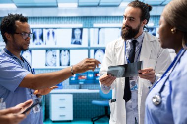 Tıbbi ekip tanısal kontrol ve tedavi planı üzerinde toplu iş yapıyor. Radyoloji alanında uzman olan doktor ve hemşireler özel bir klinikte etkili hastalıkların önlenmesini destekler..