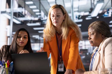 Modern bir ofiste işbirliği yapan kadın yöneticiler iş dünyasındaki kadınların verilerini analiz ediyorlar. CEO 'lar liderlik geliştirme stratejilerini tartışıyor ve birlikte mükemmelliğe ulaşıyorlar..