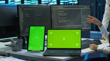 Veri merkezinde dişli enerji tüketimini yönetmek için kullanılan bilgisayar ve tabletle çalışan mühendis. Sunucu çiftliği, kamera A 'da otomasyon için kullanılan iş yerinde yeşil ekran cihazları kullanan çalışan