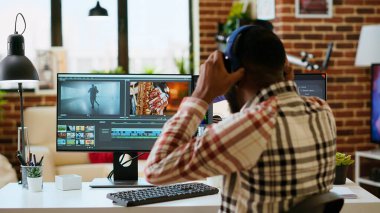 Afrikalı Amerikalı film yapımcısı profesyonel bir video çekiminde çalışıyor, bir video projesinin kurgu zaman çizelgesini yönetiyor. Modern kurgu araçları ve renk derecelendirme yazılımı çalıştırılıyor. Kamera B.