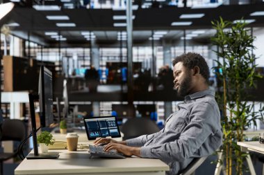 Erkek yönetici analist finansal bir rapor hazırlar ve verileri gözden geçirir, örgütsel ilerleme için bir öngörü geliştirir. Siyahi adam görev yönetimi ve strateji planlamasında yer aldı.