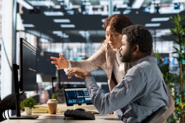 Genç çalışan ve yönetici bir bilgisayar etrafında toplanarak idari görevleri daha hızlı çözmek için hedefleri tartıştılar ve çözümler geliştirdiler. İş hedefleri ve kilometre taşlarının hizalanması.