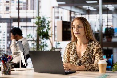 Çok uluslu bir şirkette profesyonel yönetici proje ilerlemesini ve son teslim tarihini izlemek için dizüstü bilgisayarda çalışıyor. Düzgün bir iş yönetimi ve karar verme yetkisi sağlayan bir ofis çalışanı.