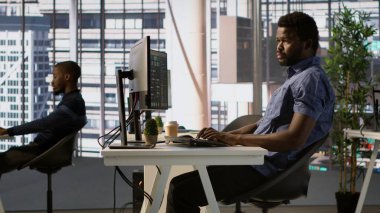 Afrika kökenli Amerikalı bir adam çeşitli programlama dilleri kullanarak yazılım uygulamaları tasarlıyor, geliştiriyor ve sürdürüyor. Sistem yöneticisi şirket sunucularını hata ayıklıyor, hataları önlüyor, kamera A