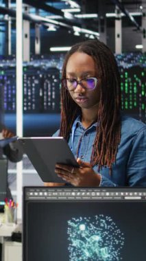 Yapay zeka oluşturulmuş veri analizi grafiklerini yorumlamak için aygıt kullanan gülen sunucu odası mühendisinin dikey video portresi. Sistem ölçümlerini gösteren yapay zeka aracı kullanan mutlu veri merkezi çalışanı