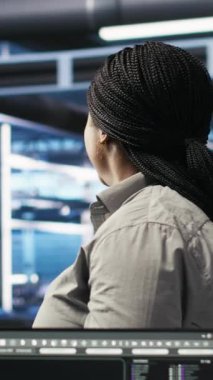 Dikey video veri merkezi yönetimi dizüstü bilgisayarla ağaç programlama yapıyor, kaynak tahsisini optimize ediyor. Sunucu odasındaki kadın bakım için öngörücü yapay zeka görselleştirme sistemleri kullanıyor.
