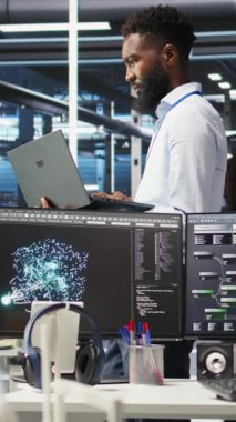 Dikey Veri Merkezi Sistem Yöneticisi, düğüm ağacı araçları kullanarak altyapı sorunlarını analiz ediyor. Sunucu merkezindeki adam, sistem sağlığını optimize etmek için yapay zeka görselleme bilgilerini kullanıyor. Kamera A.