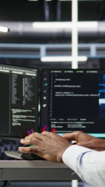 Verileri analiz etmek için yapay zeka algoritmalarını kullanarak masadaki dikey video veri merkezi bilgisayar bilimcisi. Sunucu odası bilgisayar klavyesinde yazma uzmanı, yapay zeka sinirsel kullanılıyor