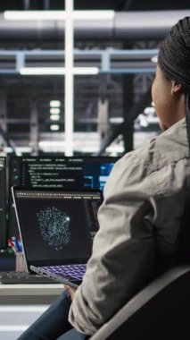 Dikey video sunucu odası bilişim uzmanı, sistem kapanma süresini en aza indirmek için yapay zeka teknolojisi uyguluyor. Yapay zeka çözümlerini optimize etmek ve uygulamak için dizüstü bilgisayar kullanan teknisyen