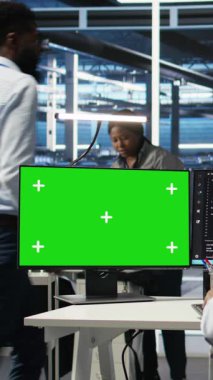 Yeşil ekran PC kullanarak parapleji yapan dikey video veri merkezi çalışanı. Özürlü sunucu merkezi yönetimi veriyi tanımlamak için model bilgisayarda görsel programlama kullanır