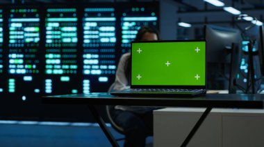 Bulanık arkaplan yönetimi sunucularında veri merkezinde teknisyen tarafından kullanılan model dizüstü bilgisayara odaklan. Sunucu merkezinde uzman tarafından ağların güvenliğini sağlamak için kullanılan kroma anahtar defterini kapat, Kamera A