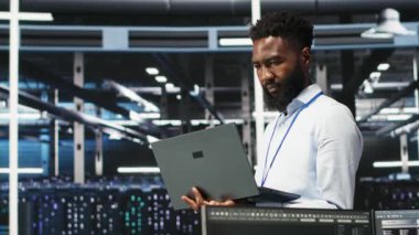 Veri merkezi sistem yöneticisi düğüm ağacı araçları kullanarak altyapı sorunlarını analiz ediyor. Sunucu merkezindeki adam, sistem sağlığını optimize etmek için yapay zeka görselleme bilgilerini kullanıyor, kamera B