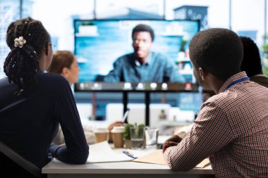 İş arkadaşları, finansmanı artırmak amacıyla bilgi grafikleri raporunu sunan bir hissedarla çevrimiçi video görüşmesi yaptılar. Personel küresel genişleme planları üzerinde çalışıyor.