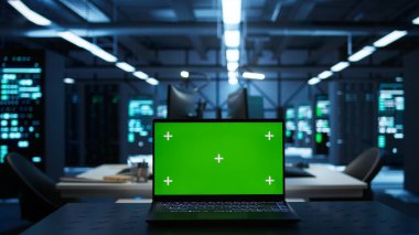 Yüksek teknoloji veri merkezindeki mühendislerin güvenlik tehditlerini izlemek için kullandıkları izole ekran laptopuna odaklan. İşçilerin yönetmeliklere uymalarını sağlamak için kullandığı krom anahtar defterini kapat