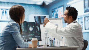 Hastanın röntgen tarama sonuçlarını inceleyen pratisyen hekim tıp kabinesinde doğru teşhis raporunu verdi. Doktor sağlık sigortası ve tıbbi teknoloji analizlerini gözden geçiriyor. Kamera A.