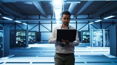 Veri merkezinde dizüstü bilgisayar kullanan, sunucuları yöneten, işletim sistemleri olan bir teknisyen. Sunucu merkezinde ağların güvenli ve düzgün çalışmasını sağlamak için dizüstü bilgisayar kullanan profesyonel kamera B