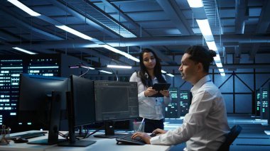 Yüksek teknoloji veri merkezindeki programcılar tablet kullanarak sorun çözüyorlar. Sunucu çiftliğinde çalışan takım arkadaşları aygıt kullanarak, performans kriterleri oluşturarak, kamera B