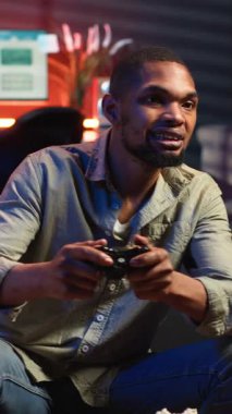 Dikey Video Afrikalı Amerikalı kızgın oyuncu, kaybettiği rakibi yüzünden hayal kırıklığına uğruyor. Oturma odasında bilgisayar oyunlarını kaybediyor. Oyun hataları olan sinirli bir insan.