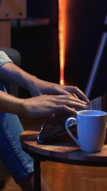 Dikey Video Self çalışanı internette gezinen, müzik dinleyen, kulaklık takan ve görevleri tamamlayan bir adam. Afro-Amerikalı adam kanepede uzanıyor ve oturma odasında dinleniyor.