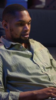 Dikey Videocu Adam mali dengeyi kontrol ediyor ve muhasebe analizi üzerinde çalışıyor. Şirketin evde gelir artışını sağlıyor. Afrika kökenli Amerikalı işçiler ekonomi istatistiklerini kullanarak uzak bir işten zevk alıyorlar. Kamera B.