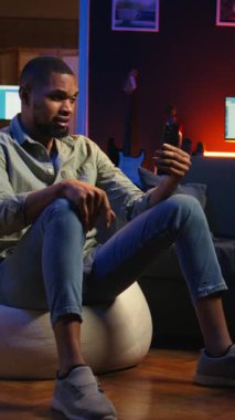 Dikey Afrikalı Amerikalı adam dizüstü bilgisayarla internet konferansına katılıyor. Günlük işleri çözmek için uzak bir web sitesine katılıyor. Oturma odasında telekonferans. Kamera A.