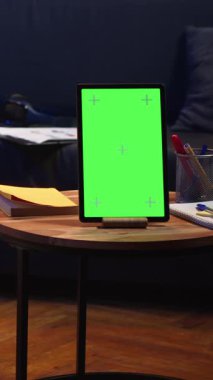 Dikey Video Siyah genç kişi yeşil ekranın yanındaki dizüstü bilgisayarı ve telefonu karıştırıyor, oturma odasındaki fasulye çuvalında rahat ve rahat hissediyor. Havalı dairesinde aletlerle mutlu sakin bir adam. Kamera.