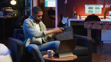 Afrikalı Amerikalı serbest yazar dizüstü bilgisayar kursuna katılıyor ve yeteneklerini geliştirmek için bir tartışmaya katılıyor. Erkek insan evinden Webinar dersinin tadını çıkarıyor, sohbet ediyor. Kamera B.