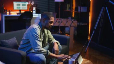 Afrika kökenli Amerikalı kişi projesiyle gurur duyuyor ve mutlu oluyor. Memleketinde birden fazla serbest iş başarıyor. Oturma odasında tezahürat yapan genç bir yetişkin. Kamera A.