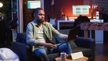 Erkek serbest çalışan, evde çalışan, kulaklıkla müzik çalan, en sevdiği şarkıları dinleyen ve uzaktan kumandalı çalışmalarına dikkat eden biri. Afrikalı Amerikalı adam programdan hoşlanıyor. Kamera B.