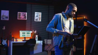 Webinar tartışmasını dinlemek için kulaklık takan siyah bir tele-işçi yeteneklerini geliştirmek için dizüstü bilgisayardaki bir derse katılıyor. Genç adam oturma odasında buluşmaktan zevk alıyor. Kamera A.