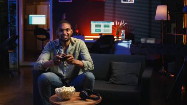 Afrikalı Amerikalı kızgın oyuncu, kaybettiği rakibi yüzünden hayal kırıklığına uğruyor. Oturma odasında bilgisayar oyunları turnuvasını kaybediyor. Oyun hatalarıyla sinirli bir insan. Kamera A.