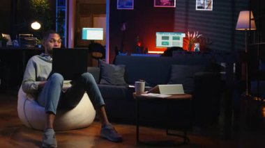 Siyahi adam internet dersine ev ortamından yeni beceriler geliştirmek için katılıyor, web konferansına katılıyor ve tavan arasından konferans seyrediyor. Sanal eğitim sınıfına katılan biri. Kamera A.