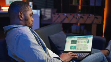 Afrikalı Amerikalı uzman, aylık gelir dengesini web platformunda kapatıyor, muhasebe analizi üzerinde çalışıyor. Yatırım yapmadan önce harcamaları ve sigortaları yöneten bir finans analisti. Kamera A.