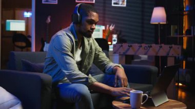 Afrikalı Amerikalı serbest yazar dizüstü bilgisayar kursuna katılıyor ve yeteneklerini geliştirmek için bir tartışmaya katılıyor. Erkek insan evinden Webinar dersinin tadını çıkarıyor, sohbet ediyor. Kamera A.