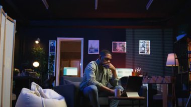 Siyahi bir adamın bazı görevlerde başarısız olmasından ve evde odaklanmaktan yorulmasından fazla mesai yaptıktan sonra bitkinlikle uğraşmasından bıktım. Çok çalışan yorgun insan dizüstü bilgisayarı kapatır ve mola verir. Kamera A.