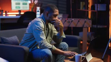 Siyahi bir adamın bazı görevlerde başarısız olmasından ve evde odaklanmaktan yorulmasından fazla mesai yaptıktan sonra bitkinlikle uğraşmasından bıktım. Çok çalışan yorgun insan dizüstü bilgisayarı kapatır ve mola verir. Kamera B.