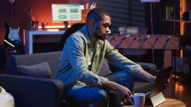 Afrika kökenli Amerikalı bir insan oturma odasındaki kablosuz bilgisayarında internete bağlanıyor, serbest çalışmayla evde dinleniyor. Adam bir tartışma içinde, günlük işleri bitirmek için birden fazla iş yapıyor. Kamera B.