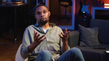 Evdeki bir video görüşmesi sırasında gülümseyen ve sohbet eden Afrikalı Amerikalı iş arkadaşlarıyla iş görüşmelerini paylaşıyor. Dijital ve kablosuz yaşam tarzı. Kamera B.