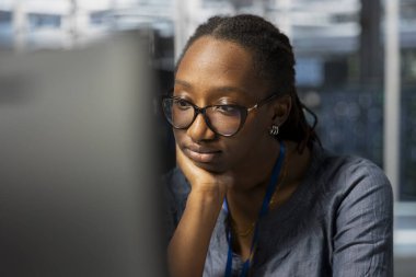 Sıkıcı veri merkezi teknisyeni, iş yerindeki ekipmanları denetliyor, monoton bakım işleri yapıyor. Sunucuda çalışan yorgun bir kadın operasyonel istikrarı sağlamak için sistem kontrolü yapıyor.