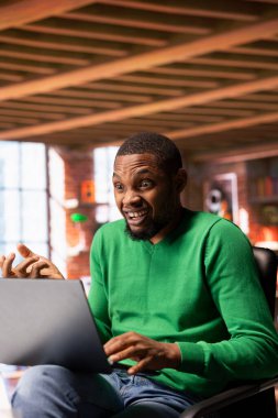 Dizüstü bilgisayarda dizüstü bilgisayar seyreden heyecanlı bir adam, çenesini düşüren olaylardan etkilenmiş, koltuğun kenarında oturuyor. Sandalyede oturan neşeli insan, şok edici film senaryosuyla şaşkına döndü.