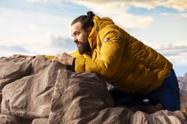Tecrübesiz, yorgun bir yürüyüşçü aşırı koşullarda dengesini kaybeder ve düşerken dengesini korumaya çalışır. Uzak vahşi doğa güzellik sunuyor ama aynı zamanda ölümcül riskler ve pervasızlıklar da sunuyor..