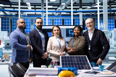 Potansiyel yatırım fırsatları üzerine araştırma yapan gülümseyen sanayi hissedarlarının portresi. Piyasa analizi yapmak ve eğilimleri belirlemek için toplanan neşeli fabrika hissedarları