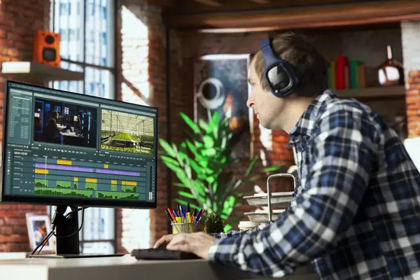 Yaratıcı ev ofisinde renk derecelendirme ve ışıklandırmayı düzenlemeden önce bilgisayar ekranında film montajını analiz eden video editörü. Yapım stüdyosu çalışanı bilgisayarda ham görüntülerle çalışıyor.